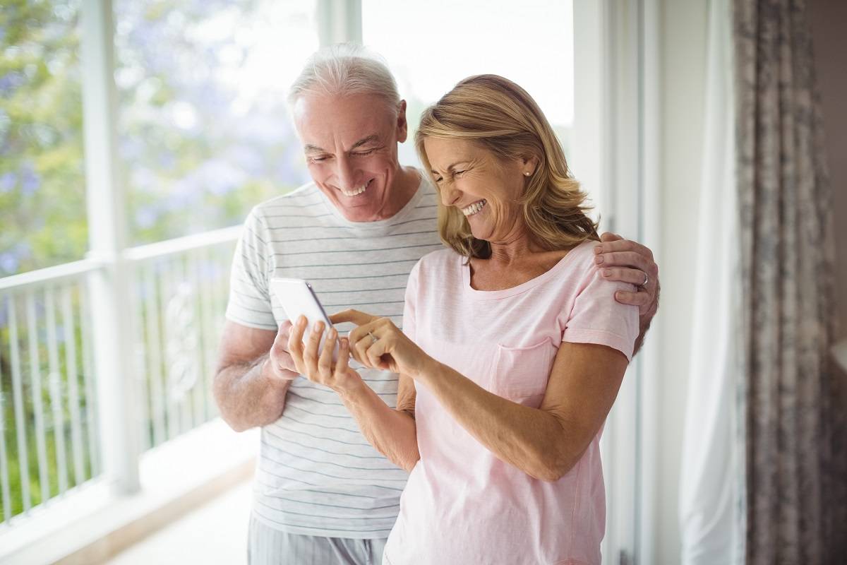 happy senior couple enjoying phone with verizon senior discount