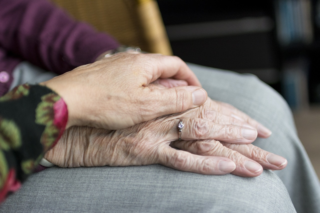 A hand on top of a senior's hand